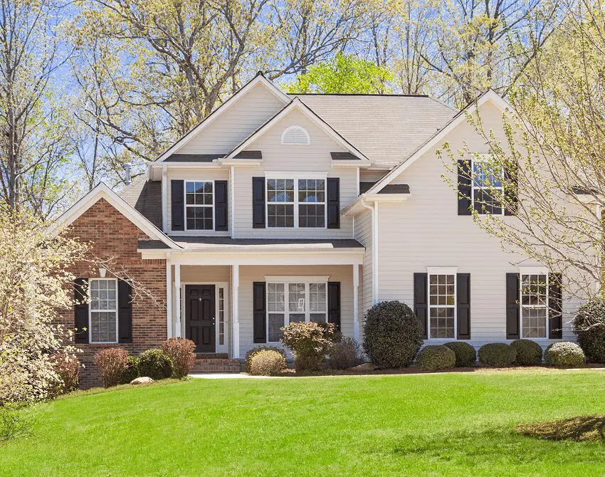 Suburban house with green lawn and trees.